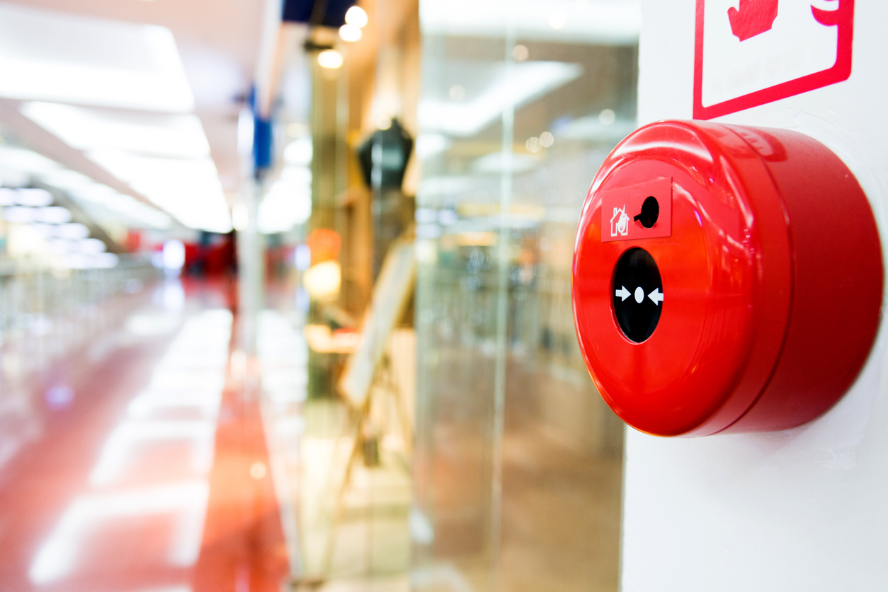 Fire alarm button on wall of shopping center.